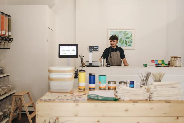 A modern retail store featuring eco-friendly, zero-waste products and a smiling cashier. Sådan finder og vurderer du butikslokaler i danske byer