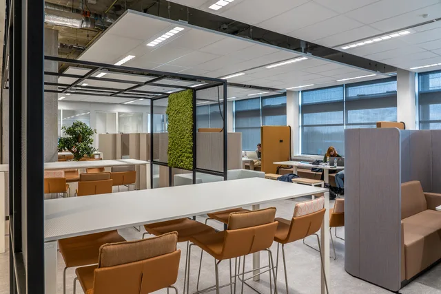 A spacious coworking office featuring modern design and natural decor elements for a collaborative environment. Indretning af erhvervslokaler: sådan planlægges et fit-out-forløb